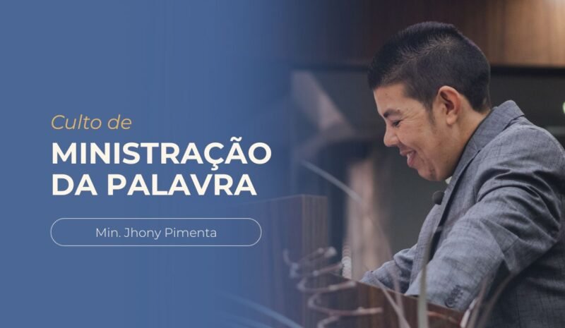 Ministro Jhony Pimenta pregando no púlpito durante o culto de ministração da palavra. Ele veste terno escuro e está posicionado atrás do púlpito.